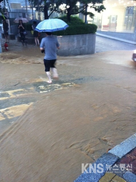 [KNS뉴스통신=박준표 기자] 27일 현재 폭우로 인해 서울 서초동 남부터미널 부근 도로가 성인 무릎 높이까지 침수되서  한 시민이 바지를 걷고 맨발로 물에 잠긴 도로를 건너는 모습이다.