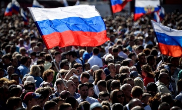 한 남성이 2019년 8월 24일 모스크바 시내에서 열린 국기의 날 기념 공연에 참가하면서 러시아 국기를 흔들고 있다. ⓒAFPBBNews