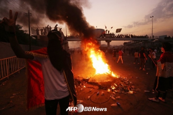 한 이라크 시위자가 2019년 10월 2일 바그다드 타야란 광장에서 국가 부패 척결 시위 도중 V 사인을 손짓하고 있다.ⓒAFPBBNews