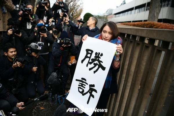 도쿄 지방 법원 앞에서 '승소'라고 적힌 종이를 내건 이토 시오리 씨 (2019 년 12 월 18 일 촬영).ⓒAFPBBNews