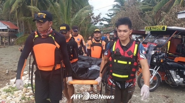 필리핀 동부 사마르 주에서 태풍에 의해 행방불명이 됐던 어업 관계자로 보이는 희생자의 시신을 운반하는 구급대원들 (2019 년 12 월 27 일 촬영)ⓒAFPBBNews