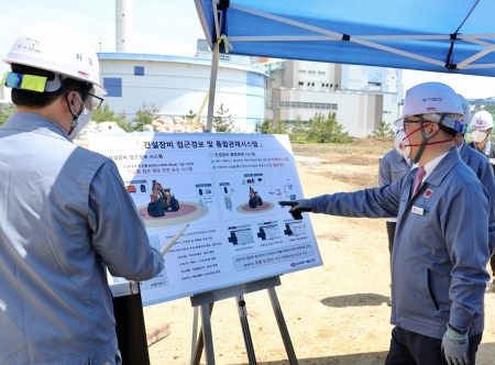 박일준 한국동서발전 사장(오른쪽)이 동해바이오화력 내 공사 현장에서 안전 보조 시스템에 대한 설명을 듣고 있다. [사진=동서발전]