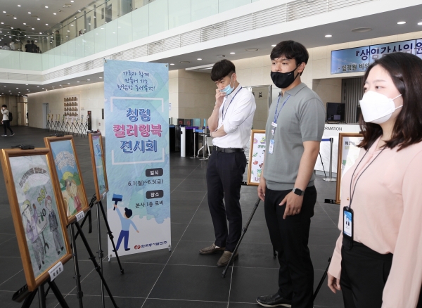 한국동서발전 직원들이 청렴 컬러링북전시회에 전시된 작품을 관람하고 있다. [사진=동서발전]