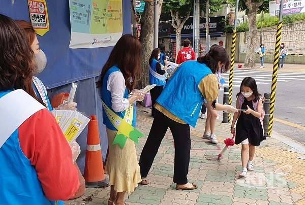 수성구 보행지킴이가 동천초등학교 앞에서 학생들에게 방역마스크를 나눠주며 스쿨존 교통안전 및 코로나19 방역 캠페인을 하고 있다. [사진=대구 수성구]