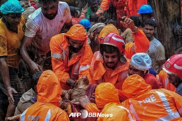 7일(현지시간) 인도 케랄라주를 강타한 폭우로 인해 산사태가 발생했다. 사진은 구조대원들이 산사태 사망자 시신을 옮기는 모습.ⓒAFPBBNews