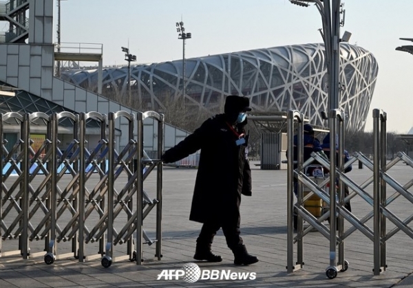 베이징 시내 올림픽 공원에서 게이트를 닫는 경비원 ⓒAFPBBNews