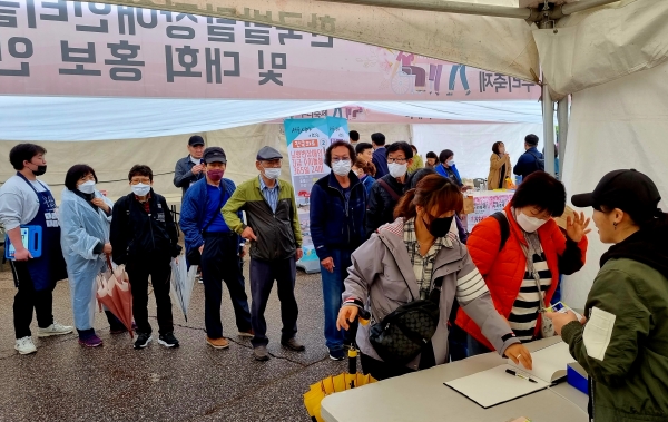 [사진] 한국발달장애인 홍보부스에 방문해 응원의 의미로 방명록을 쓰고 있는 관람객들