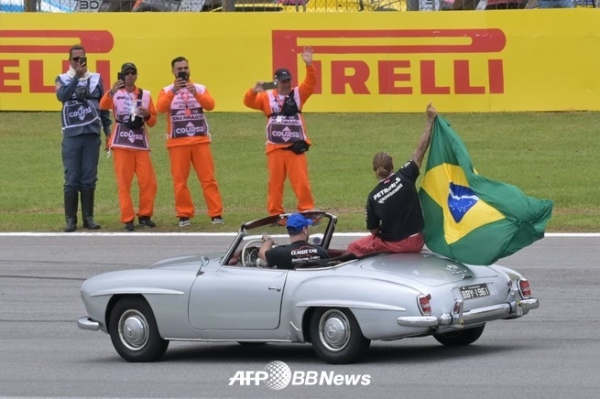2023년 11월 5일 상파울루에서 열린 포뮬러 원 브라질 그랑프리를 앞두고 메르세데스 소속 영국인 드라이버 루이스 해밀턴이 드라이버 퍼레이드에서 브라질 국기를 흔들고 있다. ⓒAFPBBNews