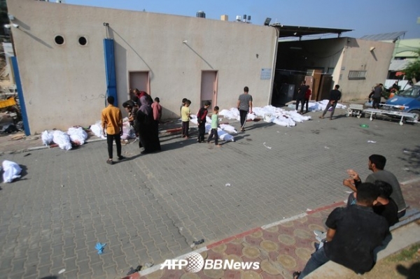팔레스타인 사람들이 가자시티의 한 병원 영안실 밖에 놓인 희생자의 시신 앞을 지나가고 있다. 2023.11.01 ⓒAFPBBNews