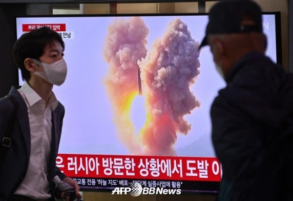 서울역에서 한 남성이 북한 미사일 실험 장면이 담긴 뉴스 방송이 나오는 텔레비전 화면 앞을 지나가고 있다. 2023.09.13 ⓒAFPBBNews